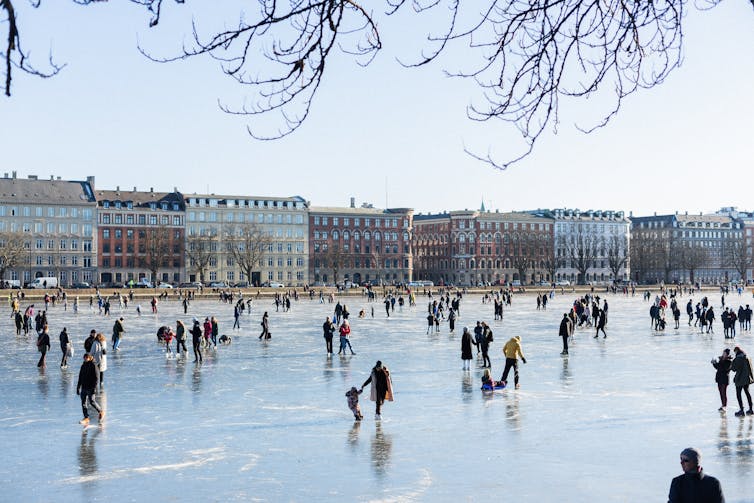 People ice-skating outdoors in a city.